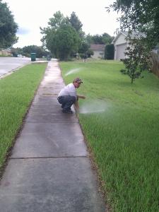 an Alexandria Sprinkler Repair tech tests a newly installed pop up head